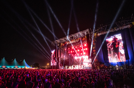 Description: A large crowd of people in front of a stage with a large screenDescription automatically generated with low confidence